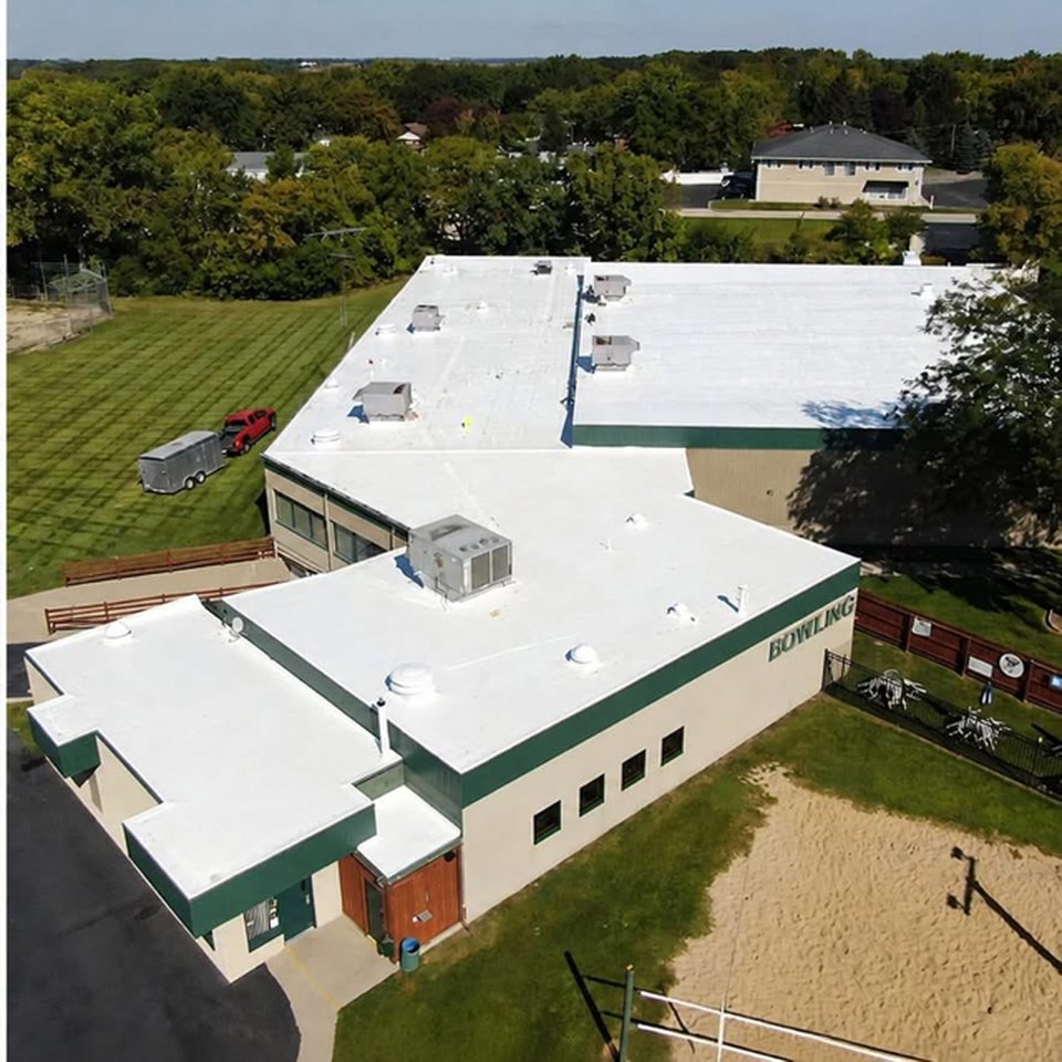 After: the same bowling center roof finished with a bright white Conklin reflective coating system